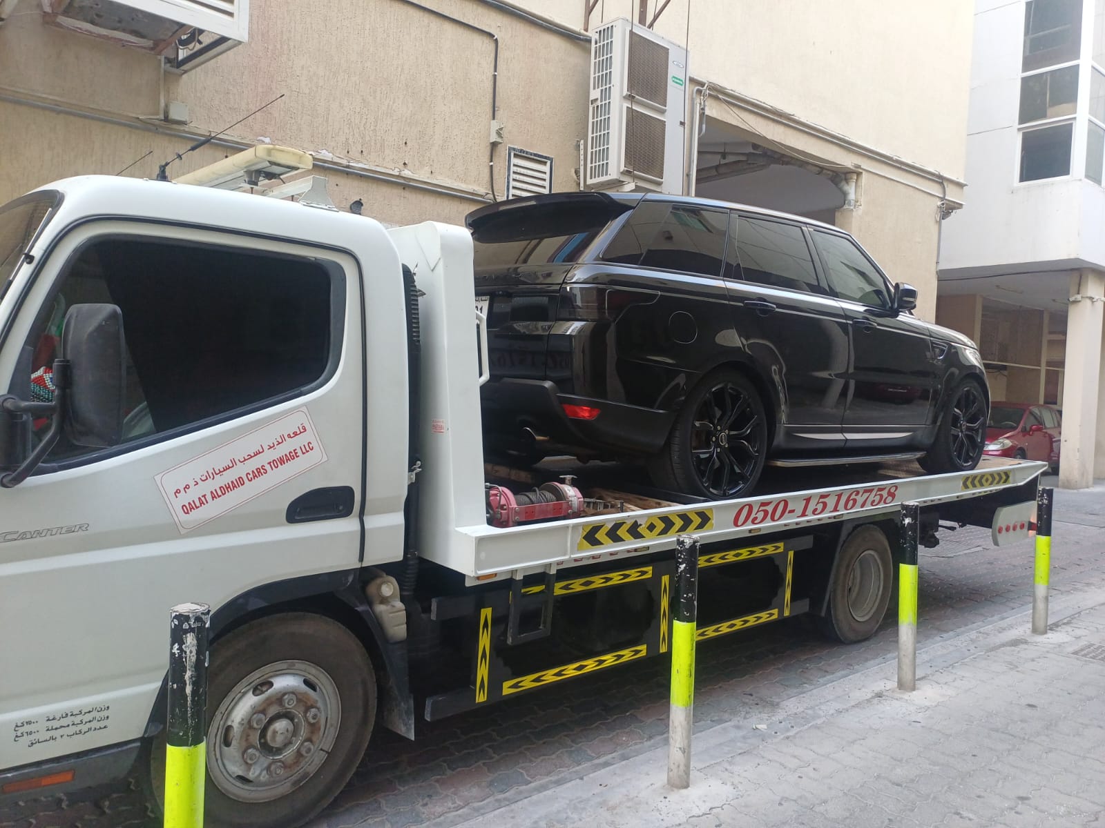 Hamza Towing Service Red Dodge flatbed recovery in Sharjah at night